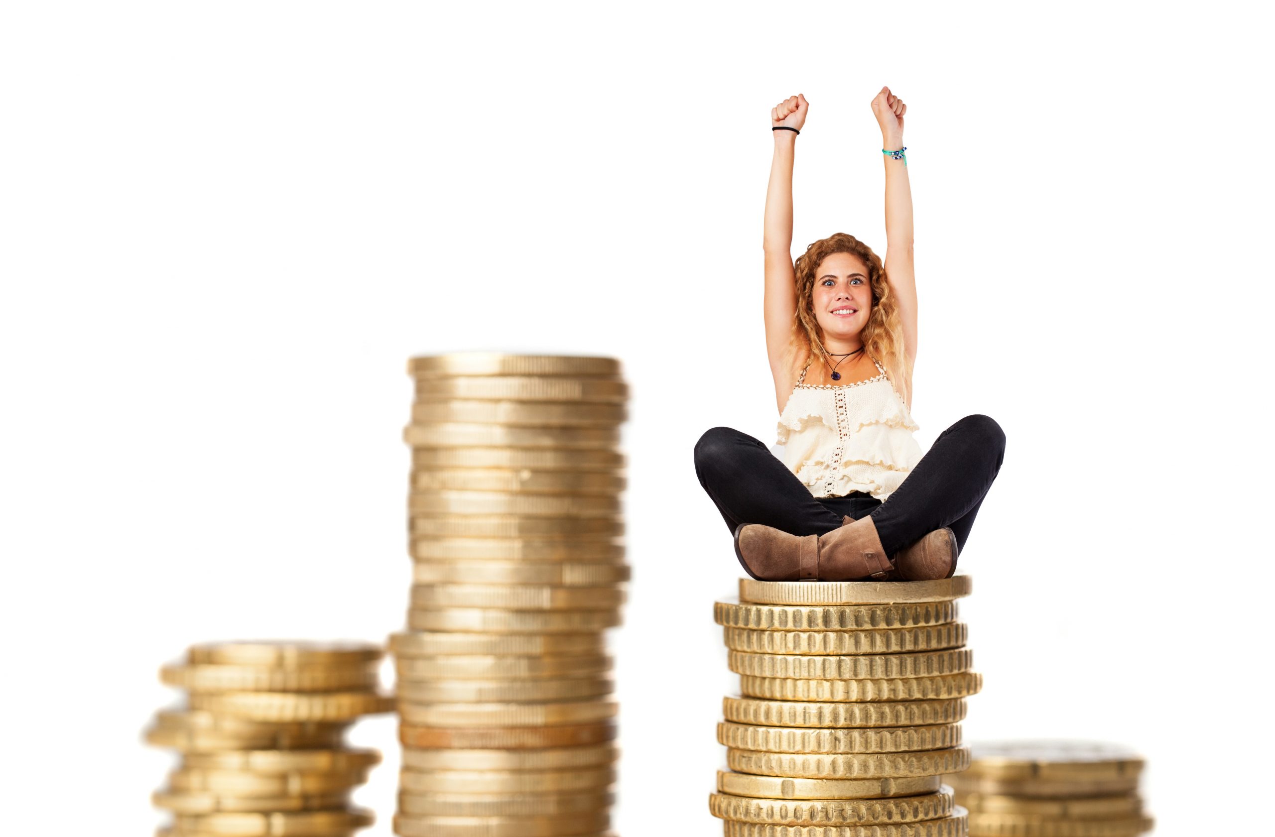 young woman doing a winner gesture sitting on a coins pile